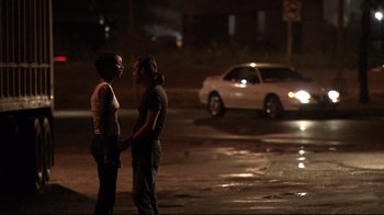 Movie still from “Chop Shop” (2007), directed by Ramin Bahrani – Two people standing on the side of the road at night; Medium shot, Over the shoulder angle