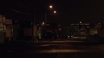 Movie still from “Chop Shop” (2007), directed by Ramin Bahrani – A street light shines in the dark on a dark night; Extreme Wide shot, High angle