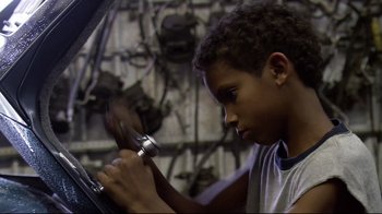 Movie still from “Chop Shop” (2007), directed by Ramin Bahrani – A young boy working on a car in a garage; Close Up shot, Low angle