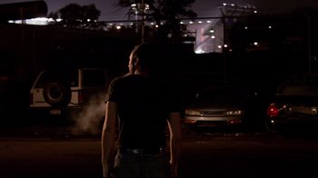 Movie still from “Chop Shop” (2007), directed by Ramin Bahrani – A man standing in the dark near a car; Medium shot, Over the shoulder angle