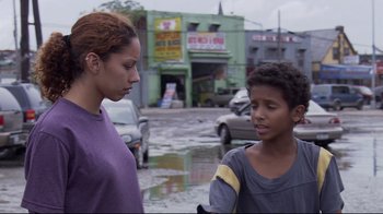 Movie still from “Chop Shop” (2007), directed by Ramin Bahrani – A woman talking to a young boy on the side of the road; Medium shot, Over the shoulder angle