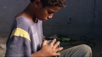 Movie still from “Chop Shop” (2007), directed by Ramin Bahrani – A young boy is holding something in his hands; Close Up shot, Low angle