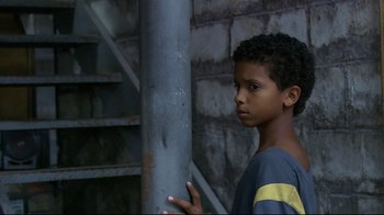 Movie still from “Chop Shop” (2007), directed by Ramin Bahrani – A young boy standing next to a metal pole; Close Up shot, Low angle