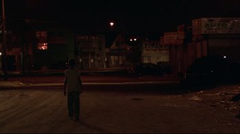 Movie still from “Chop Shop” (2007), directed by Ramin Bahrani – A man standing on the street in the dark; Extreme Wide shot, High angle