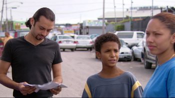 Movie still from “Chop Shop” (2007), directed by Ramin Bahrani – A young man standing next to another man on a street; Medium shot, Over the shoulder angle