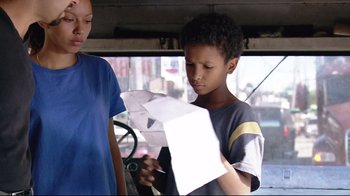 Movie still from “Chop Shop” (2007), directed by Ramin Bahrani – A boy is looking at a piece of paper; Medium shot, Low angle