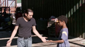 Movie still from “Chop Shop” (2007), directed by Ramin Bahrani – A man and a boy are shaking hands outside; Medium shot, Over the shoulder angle