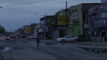 Movie still from “Chop Shop” (2007), directed by Ramin Bahrani – A person riding a scooter down a city street at night; Extreme Wide shot, High angle