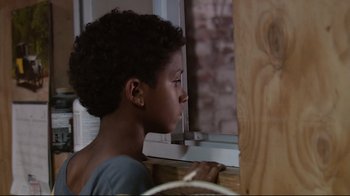 Movie still from “Chop Shop” (2007), directed by Ramin Bahrani – A young boy looking out of a window; Close Up shot, Over the shoulder angle