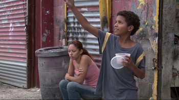 Movie still from “Chop Shop” (2007), directed by Ramin Bahrani – A boy and a girl sitting on the side of a building; Medium shot, Low angle