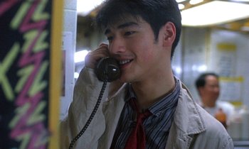 Movie still from “Chungking Express” (1994), directed by Kar-Wai Wong – A young man talking on a phone while wearing a jacket and tie; Close Up shot, Over the shoulder angle