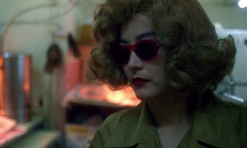 Movie still from “Chungking Express” (1994), directed by Kar-Wai Wong – A woman wearing a green shirt and red sunglasses; Close Up shot, Over the shoulder angle