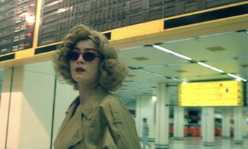 Movie still from “Chungking Express” (1994), directed by Kar-Wai Wong – A woman in a tan jacket and red sunglasses; Close Up shot, Low angle