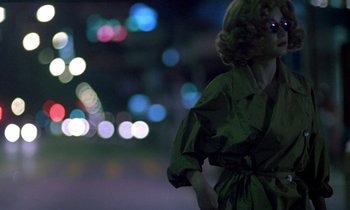 Movie still from “Chungking Express” (1994), directed by Kar-Wai Wong – A woman in a green dress standing on the street; Medium shot, Low angle