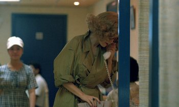 Movie still from “Chungking Express” (1994), directed by Kar-Wai Wong – A woman is talking on the phone while standing in a room; Medium shot, Over the shoulder angle