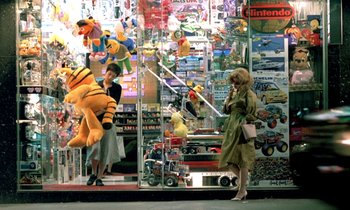 Movie still from “Chungking Express” (1994), directed by Kar-Wai Wong – A woman standing in front of a store with a winnie the pooh stuffed animal; Wide shot, High angle