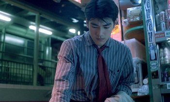 Movie still from “Chungking Express” (1994), directed by Kar-Wai Wong – A man in a striped shirt and red neck tie; Medium shot, Low angle