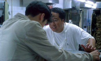 Movie still from “Chungking Express” (1994), directed by Kar-Wai Wong – Two men are talking in the kitchen together; Close Up shot, Over the shoulder angle