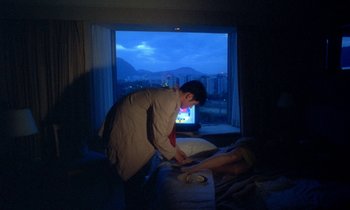 Movie still from “Chungking Express” (1994), directed by Kar-Wai Wong – A man standing over a woman in a bed in front of a window; Medium shot, Over the shoulder angle
