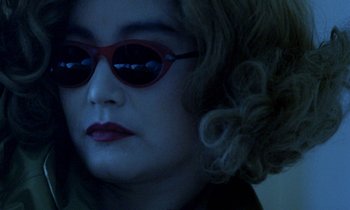 Movie still from “Chungking Express” (1994), directed by Kar-Wai Wong – A person wearing sunglasses; Close Up shot, Over the shoulder angle