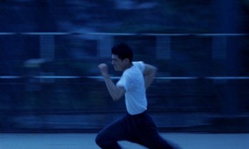 Movie still from “Chungking Express” (1994), directed by Kar-Wai Wong – A young man running on a sidewalk at night; Medium shot, High angle