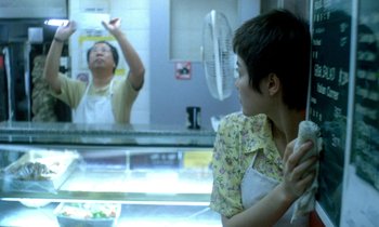 Movie still from “Chungking Express” (1994), directed by Kar-Wai Wong – A woman in an apron looks at a man in an apron in a kitchen; Medium shot, Over the shoulder angle