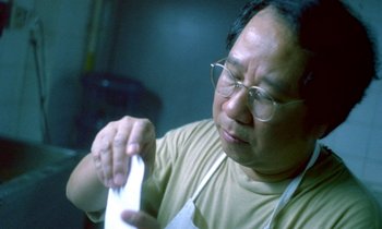 Movie still from “Chungking Express” (1994), directed by Kar-Wai Wong – A man in a tan shirt holding a white towel; Close Up shot, Low angle