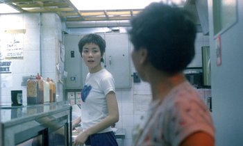 Movie still from “Chungking Express” (1994), directed by Kar-Wai Wong – A woman standing in front of another woman in a kitchen; Medium shot, Over the shoulder angle