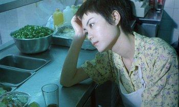 Movie still from “Chungking Express” (1994), directed by Kar-Wai Wong – A woman sitting at a table with a glass of orange juice in front of her; Close Up shot, High angle