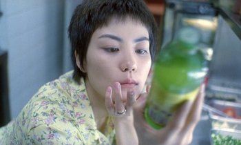 Movie still from “Chungking Express” (1994), directed by Kar-Wai Wong – A woman holding a glass of green juice; Close Up shot, High angle