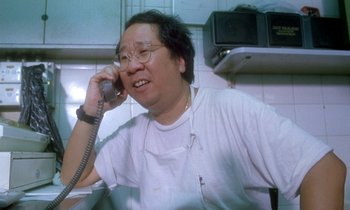 Movie still from “Chungking Express” (1994), directed by Kar-Wai Wong – A man talking on a phone while sitting in a kitchen; Close Up shot, High angle