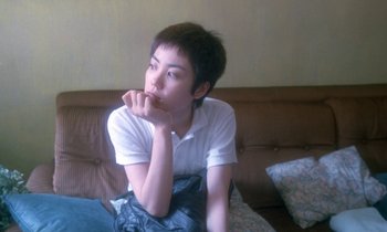 Movie still from “Chungking Express” (1994), directed by Kar-Wai Wong – A person sitting on a couch with a hand under their chin; Close Up shot, High angle