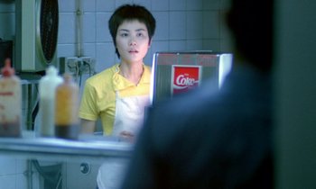 Movie still from “Chungking Express” (1994), directed by Kar-Wai Wong – A man in a yellow shirt is looking in the mirror; Medium shot, Over the shoulder angle