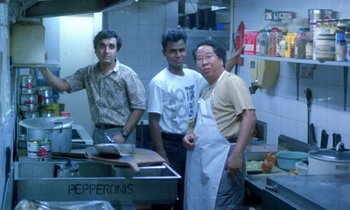 Movie still from “Chungking Express” (1994), directed by Kar-Wai Wong – A group of men standing in a kitchen preparing food; Medium shot, High angle