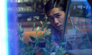Movie still from “Chungking Express” (1994), directed by Kar-Wai Wong – A man looking out of a window with a plant in front of him; Close Up shot, High angle