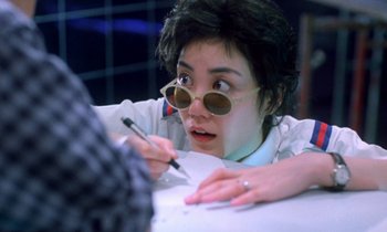 Movie still from “Chungking Express” (1994), directed by Kar-Wai Wong – A woman with glasses writing with a pen; Close Up shot, Over the shoulder angle