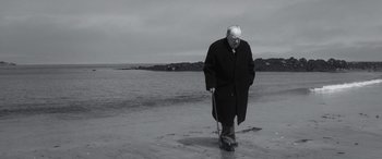 Movie still from “Churchill” (2017), directed by Jonathan Teplitzky – An older man walking on the beach with a cane; Medium shot, Low angle