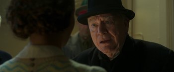Movie still from “Churchill” (2017), directed by Jonathan Teplitzky – An older man wearing a black hat looking at another man; Close Up shot, Over the shoulder angle
