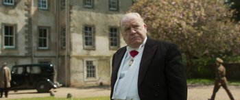 Movie still from “Churchill” (2017), directed by Jonathan Teplitzky – An older man wearing a suit and tie; Close Up shot, Over the shoulder angle