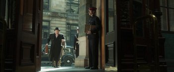 Movie still from “Churchill” (2017), directed by Jonathan Teplitzky – A man in a uniform stands on the side of the street; Wide shot, Low angle