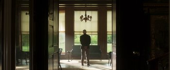 Movie still from “Churchill” (2017), directed by Jonathan Teplitzky – A man standing in front of a window in a room; Wide shot, Low angle