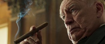 Movie still from “Churchill” (2017), directed by Jonathan Teplitzky – An older man holding a cigar in his hand; Close Up shot, Low angle