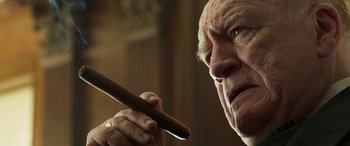 Movie still from “Churchill” (2017), directed by Jonathan Teplitzky – An older man holding a cigar in his hand; Close Up shot, Low angle