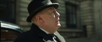 Movie still from “Churchill” (2017), directed by Jonathan Teplitzky – An older man wearing a suit and a hat; Close Up shot, Low angle