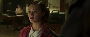 Movie still from “Churchill” (2017), directed by Jonathan Teplitzky – A young woman with red lipstick looking at the camera; Close Up shot, Over the shoulder angle