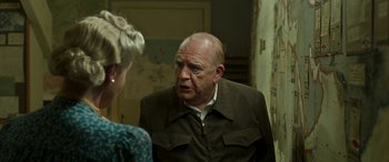 Movie still from “Churchill” (2017), directed by Jonathan Teplitzky – An older man talking to a woman in a room; Medium shot, Over the shoulder angle