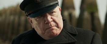 Movie still from “Churchill” (2017), directed by Jonathan Teplitzky – An older man wearing a black hat and a black coat; Close Up shot, Low angle