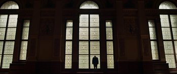 Movie still from “Churchill” (2017), directed by Jonathan Teplitzky – A man standing in front of a large stained glass window; Extreme Wide shot, Low angle