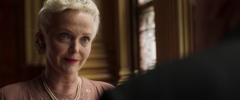 Movie still from “Churchill” (2017), directed by Jonathan Teplitzky – An older woman wearing a pink dress and a pearl necklace; Close Up shot, Over the shoulder angle