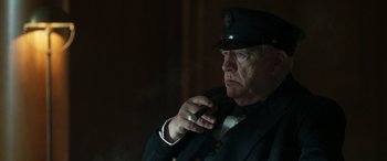 Movie still from “Churchill” (2017), directed by Jonathan Teplitzky – An older man in a uniform is smoking a cigarette; Close Up shot, Low angle